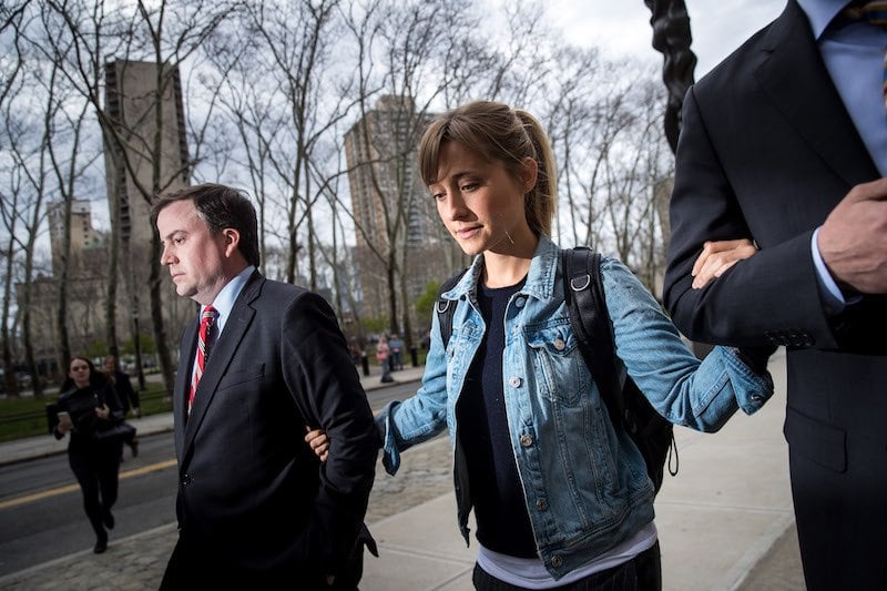 Allison Mack holds on to the arms of her two lawyers Allison Mack holds on to the arms of her two lawyers