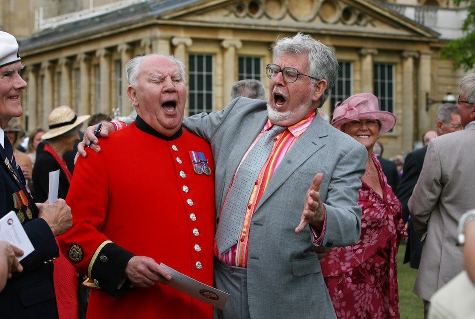 Rolf Harris sings a song with Chelsea pensioner David Poultney at a Buckingham Palace garden party