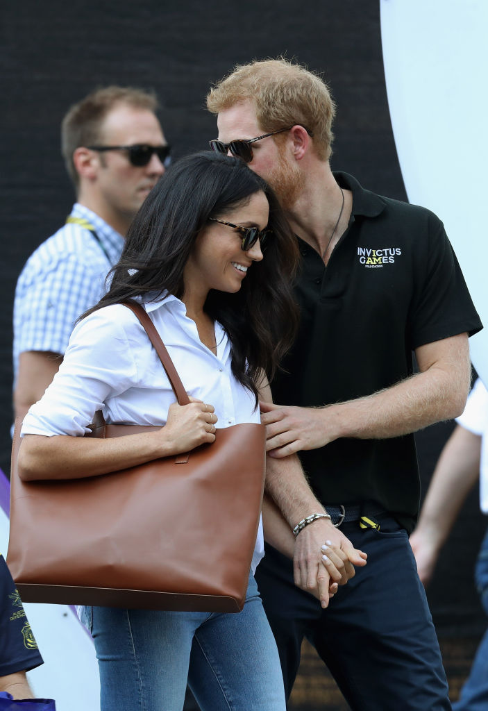 Prince Harry and Meghan Markle hold hands a Wheelchair Tennis match during the Invictus Games 2017