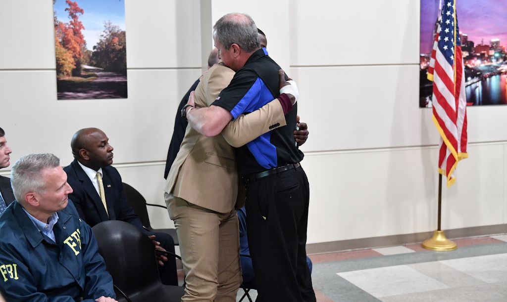 Waffle House President and CEO, Walt Ehmer embraces patron James Shaw Jr. at a press conference.