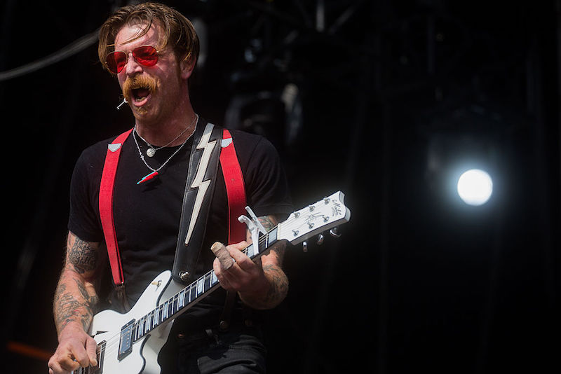 Jesse Hughes playing guitar on stage. Jesse Hughes playing guitar on stage.