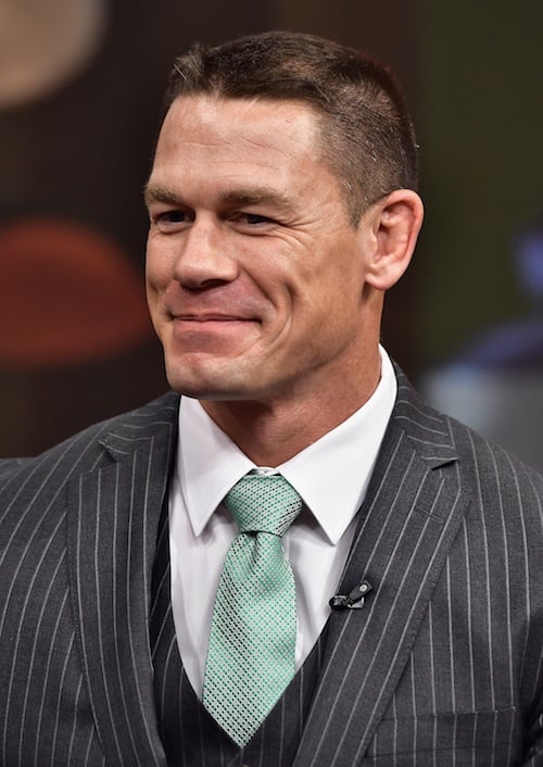 John Cena smiling while wearing a suit, vest and tie. John Cena smiling while wearing a suit, vest and tie.