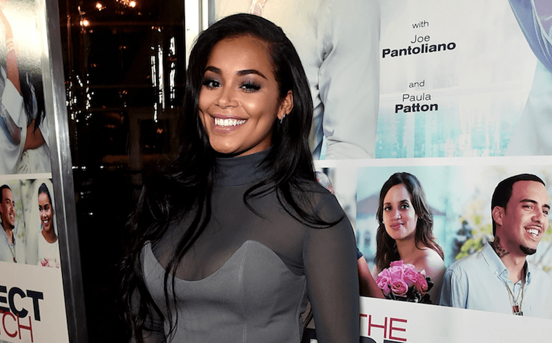 Lauren London smiling while on the red carpet of a movie premiere. Lauren London smiling while on the red carpet of a movie premiere.