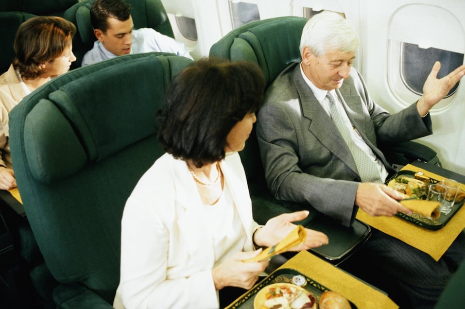 Man and woman on airplane having airline food