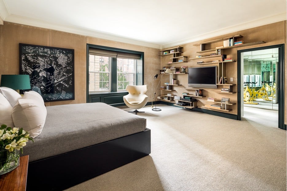 Large master bedroom with tan walls and shelving
