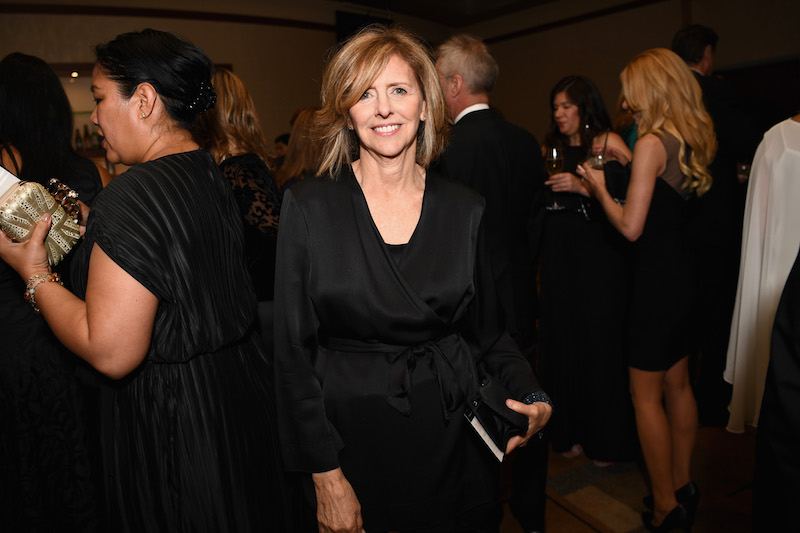 Nancy Meyers poses in a black dress at a party. 