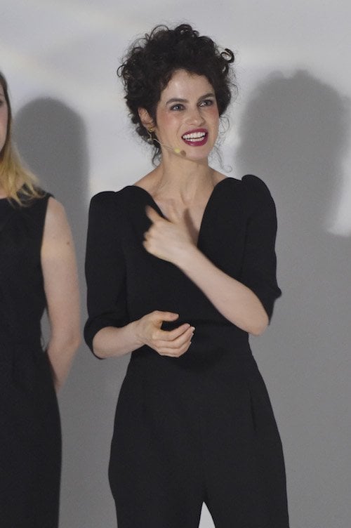 Oxman speaks on stage while wearing a black ensemble. Oxman speaks on stage while wearing a black ensemble.