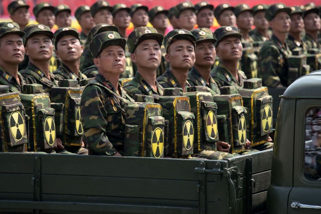 Korean People's Army (KPA) soldiers carrying packs marked with a radioactive symbol