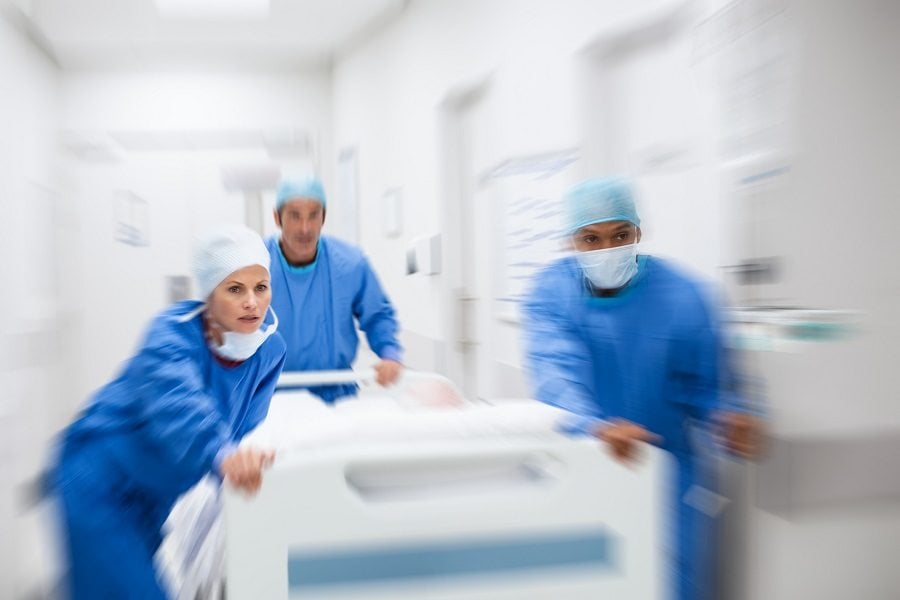 Doctors rushing with Patient lying on bed Doctors rushing with Patient lying on bed