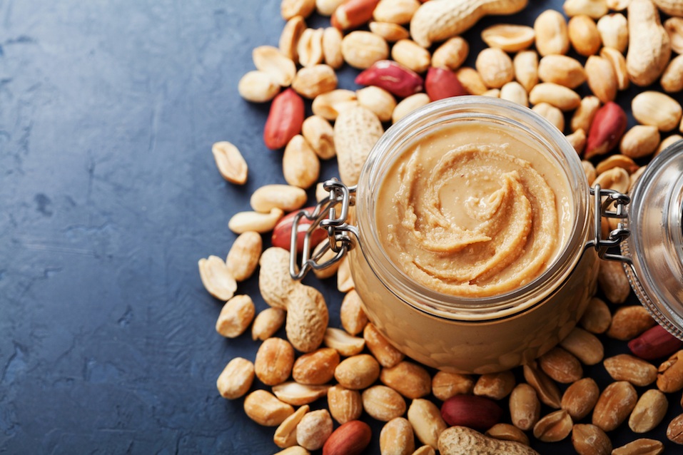 Peanut butter jar and heap of nuts