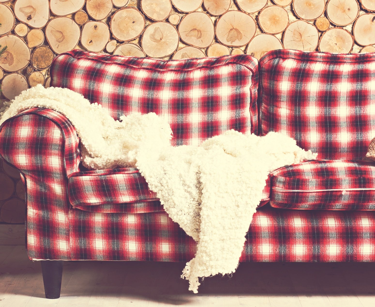Red Plaid couch with wooden wall