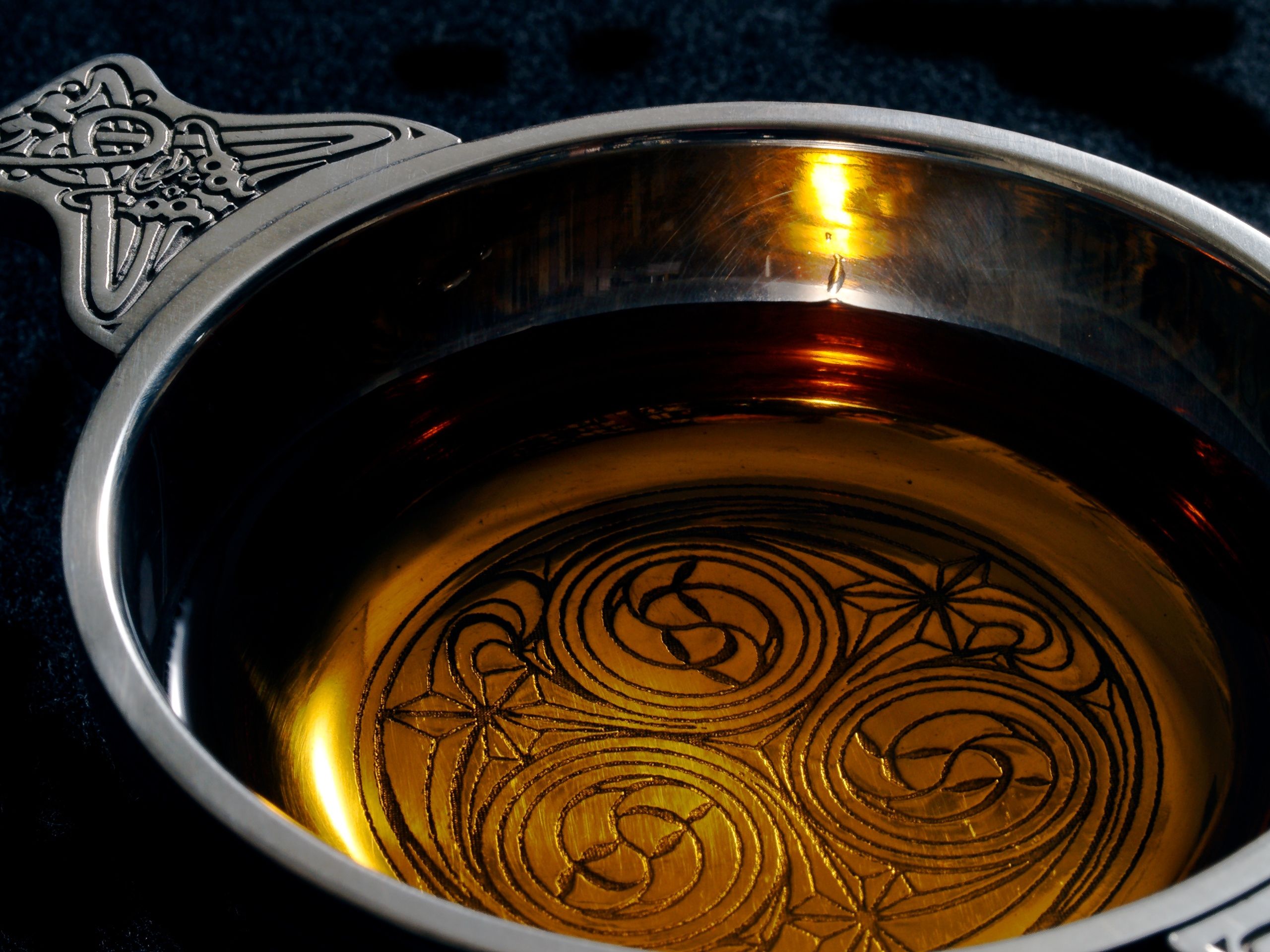A traditional Scottish cup, a quaich, with a dram of single malt whiskey.