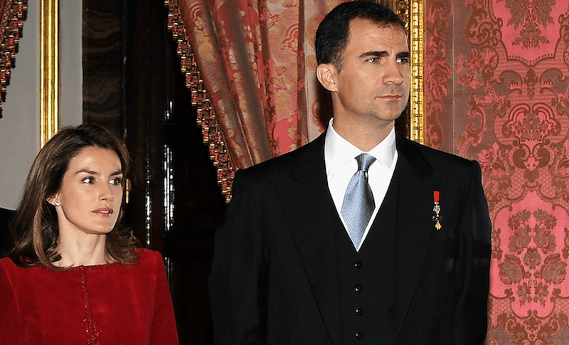 Queen Letizia stands next to Prince Felipe at a formal event. 