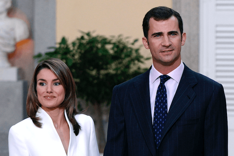 Queen Letizia stands in a white suit next to Prince Felipe. 