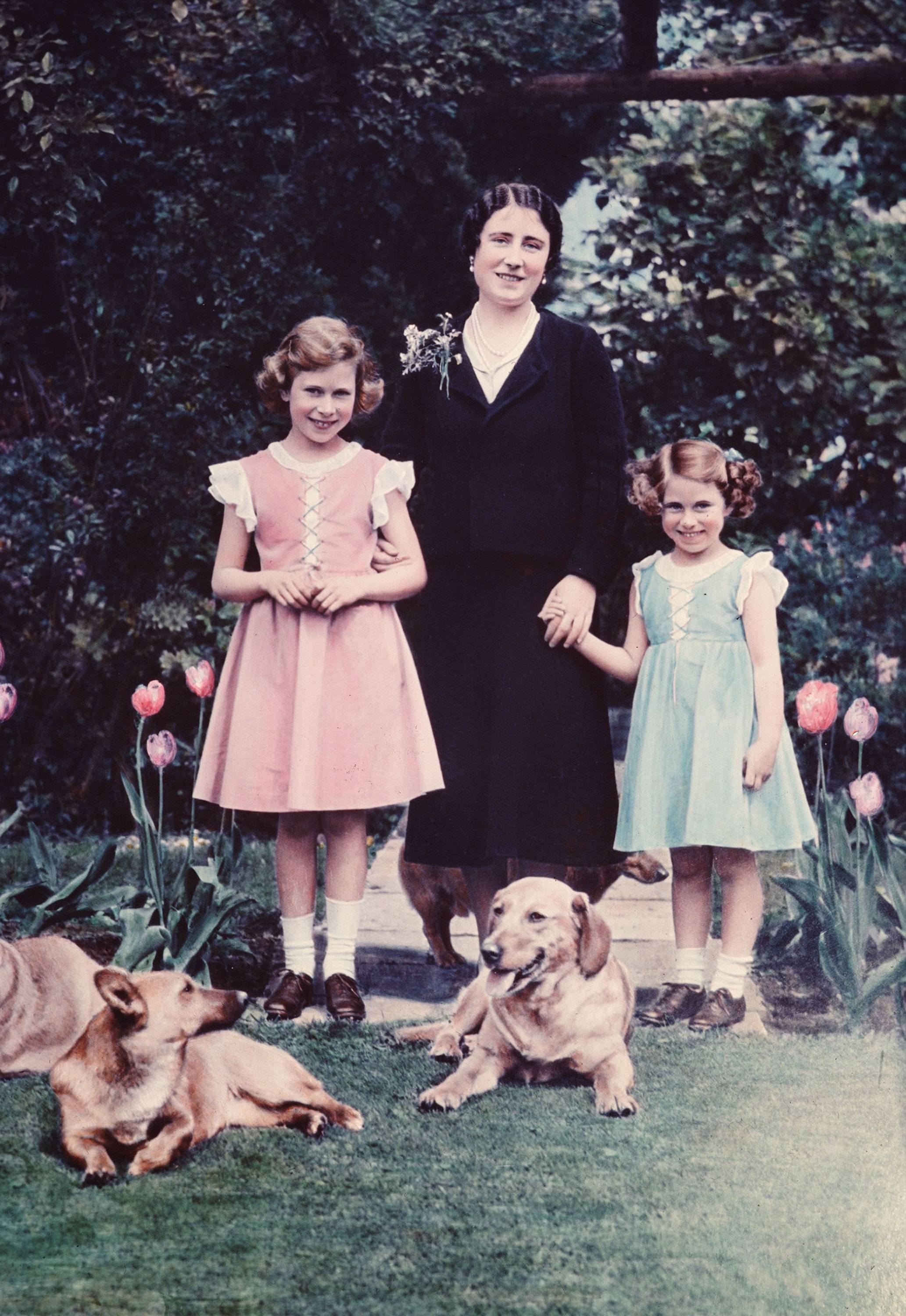 Britain's Queen Elizabeth, center, poses with her two daughters, Princess Elizabeth, left, and Princess Margaret, in June 1936 in the garden of the Royal Lodge at Windsor, England.