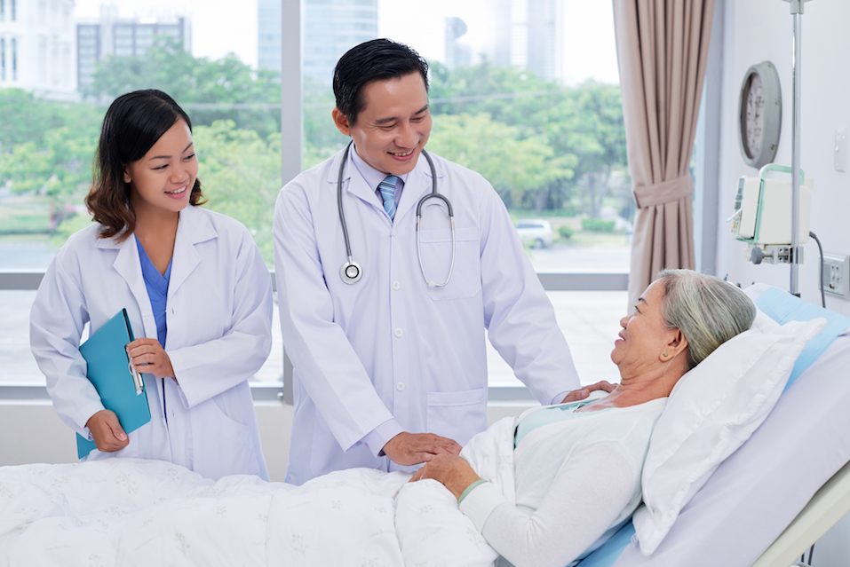 doctor and nurse talking to senior patient recovering