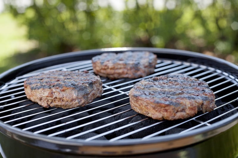 hamburgers grilling on charcoal grill