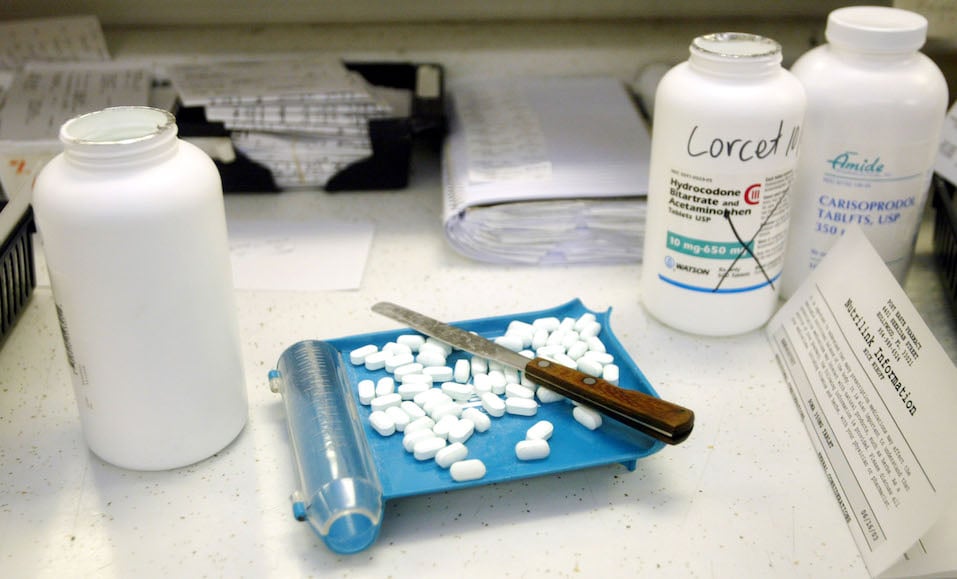 A pharmaceutical technician prepares to separate a prescription of the generic drug Lorcet at the Post Haste Pharmacy
