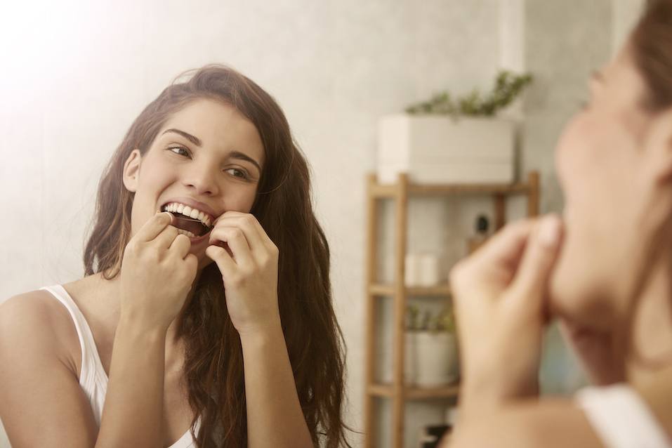 Woman is using dental floss