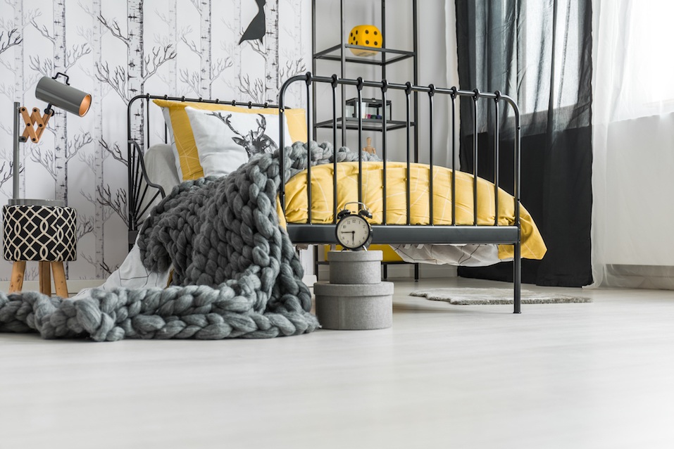 Grey woolen handmade blanket falling off the bed