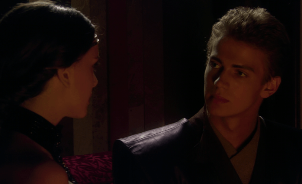 Anakin and Padme talk to each other near the fireplace. 