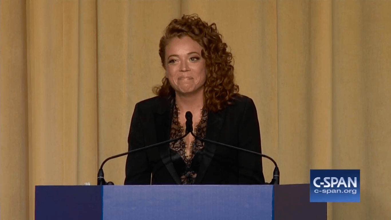 Michelle Wolf at a podium Michelle Wolf at a podium