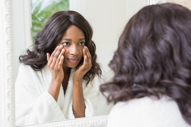 Woman checking her skin in bathroom Woman checking her skin in bathroom