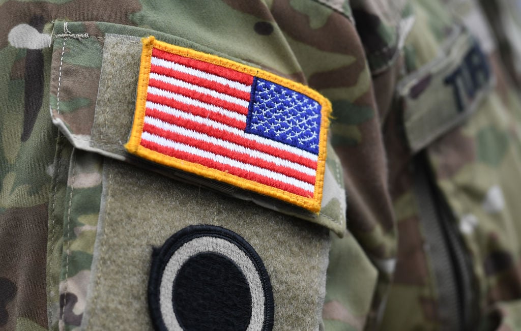 A US flag is pictured on a soldier's uniform