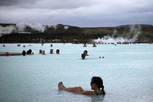 People bath in the "Blue lagoon " geothermal spa, one of the most visited attractions in Iceland in the Reykjanes peninsula, southwestern Iceland on July 5, 2014. The spa is located on a lava field. People bath in the "Blue lagoon " geothermal spa, one of the most visited attractions in Iceland in the Reykjanes peninsula, southwestern Iceland on July 5, 2014. The spa is located on a lava field.