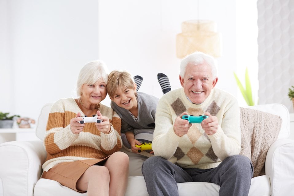 Boy playing video games with his grandparents