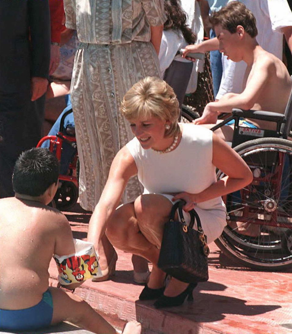 Princess Diana shakes hands with a child on the ground Princess Diana shakes hands with a child on the ground