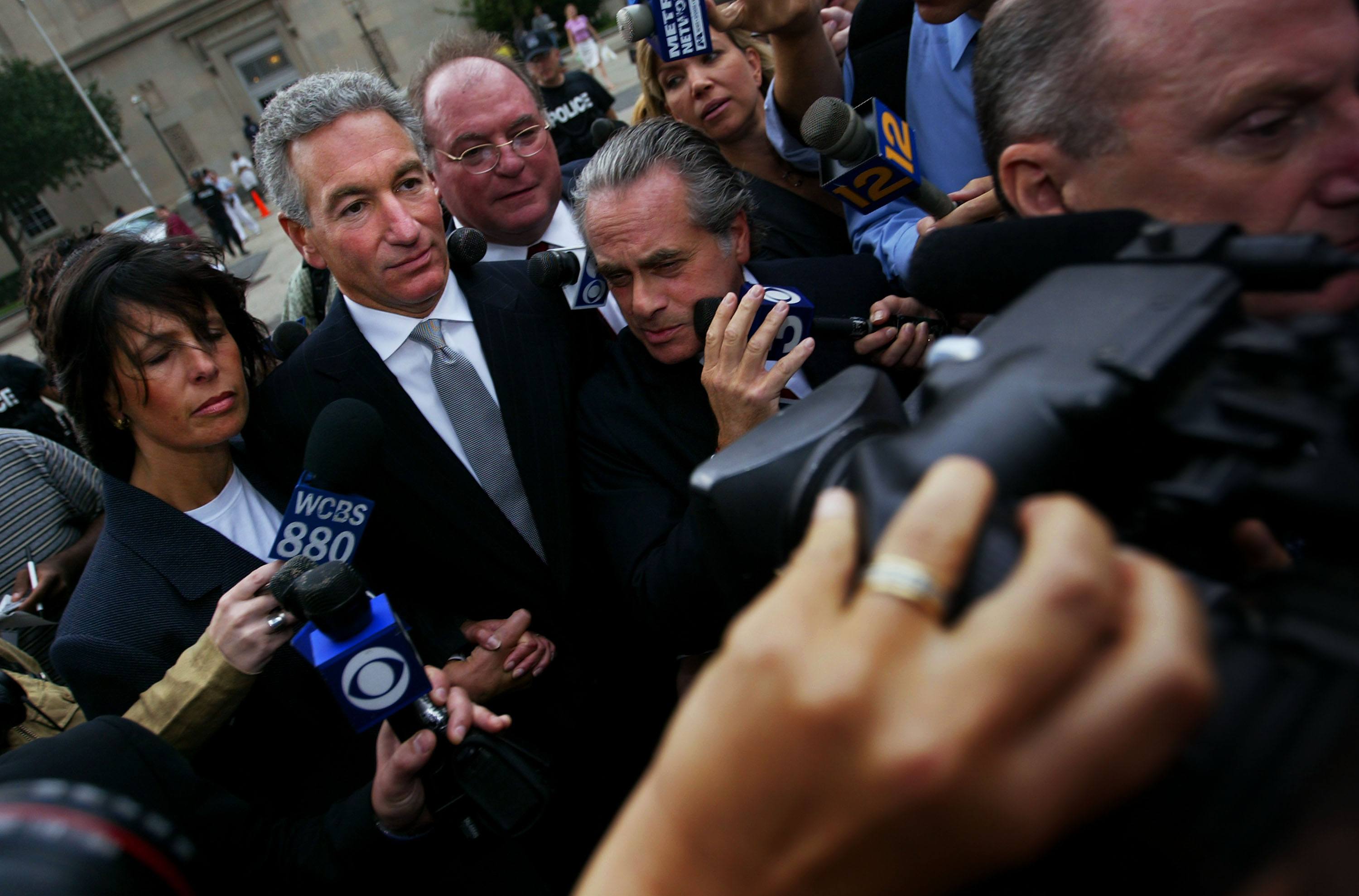 Charles Kushner (C) wades though the media with his legal team and wife
