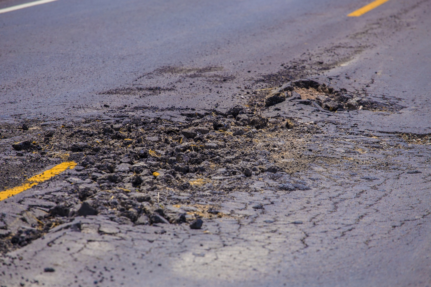 Damage asphalt concrete road. The hole is in center of the road.