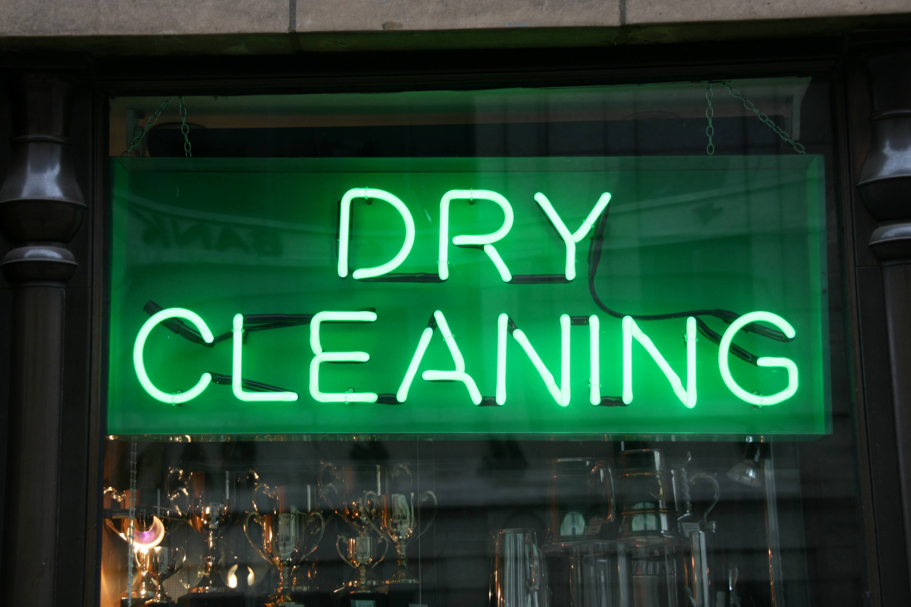 Close-up of a neon green dry cleaning sign in a window