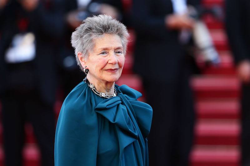 Emmanuelle Riva wearing a blue dress on a red carpet. Emmanuelle Riva wearing a blue dress on a red carpet.