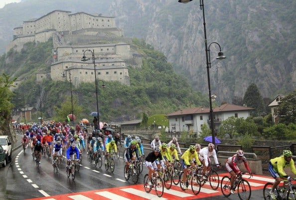 The pack rides with the Fort of Bard in the background during the 14th stage of the Tour of Italy cycling race
