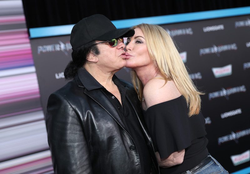 Gene Simmons and Shannon Tweed kissing on a red carpet.