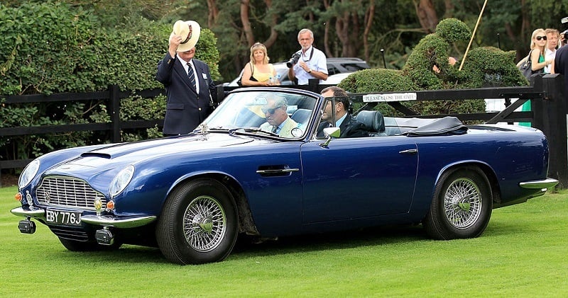 EGHAM, ENGLAND - JULY 25: Prince Charles, Prince of Wales arrves in his Aston Martin at Guards Polo Club for the Cartier International Polo Day on July 25, 2010 in Egham, England.