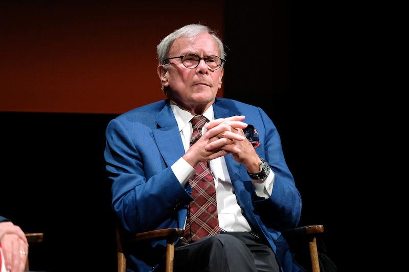 Tom Brokaw sits on a chair with his fingers clasped together. Tom Brokaw sits on a chair with his fingers clasped together.