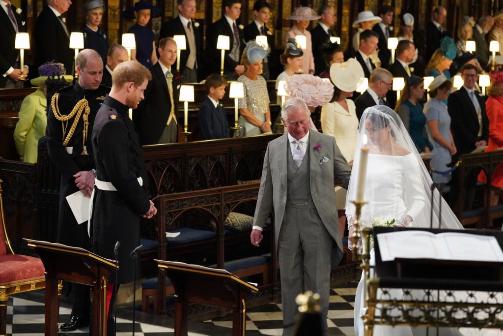 Prince Harry looks at his bride, Meghan Markle, as she arrives accompanied by Prince Charles, Prince of Wales during their wedding in St George's Chapel at Windsor Castle on May 19, 2018 in Windsor, England.