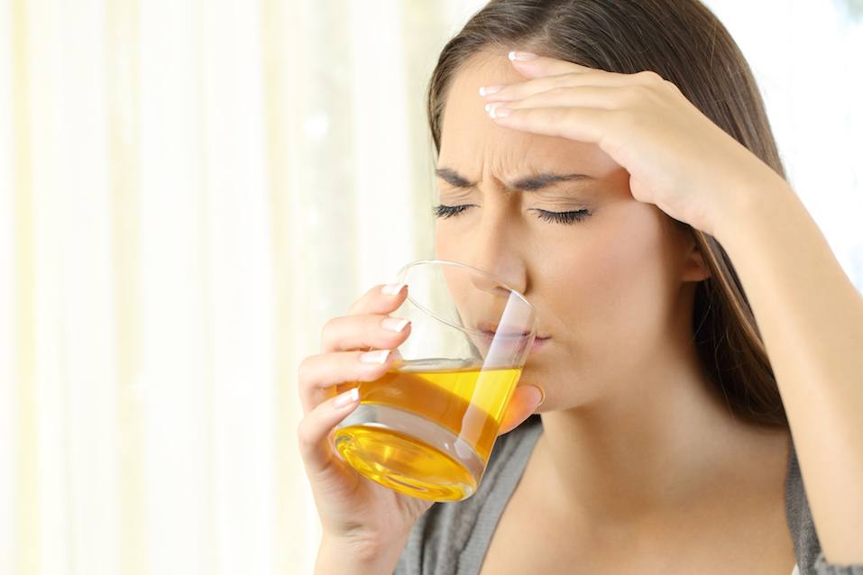 Girl suffering headache drinking a medicine