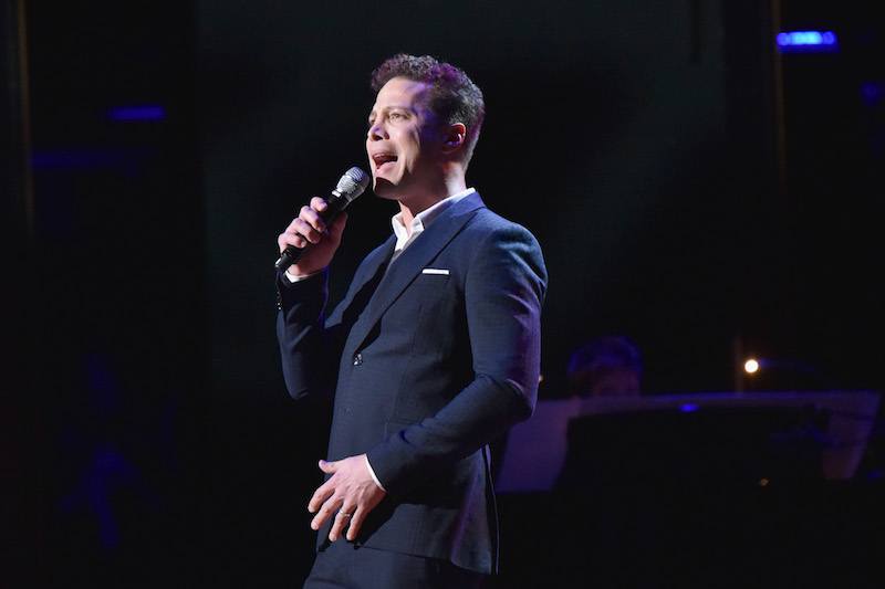 Justin Guarini singing into a microphone.  Justin Guarini singing into a microphone.