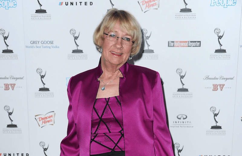 Kathryn Joosten wearing a pink outfit on a red carpet. 
