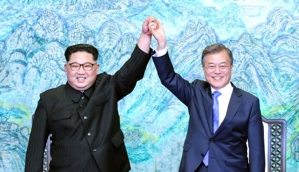 North Korean leader Kim Jong Un (L) and South Korean President Moon Jae-in (R) pose for photographs