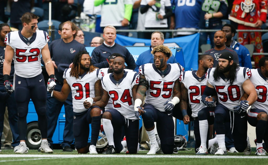 Members of the Houston Texans stand and kneel before the game