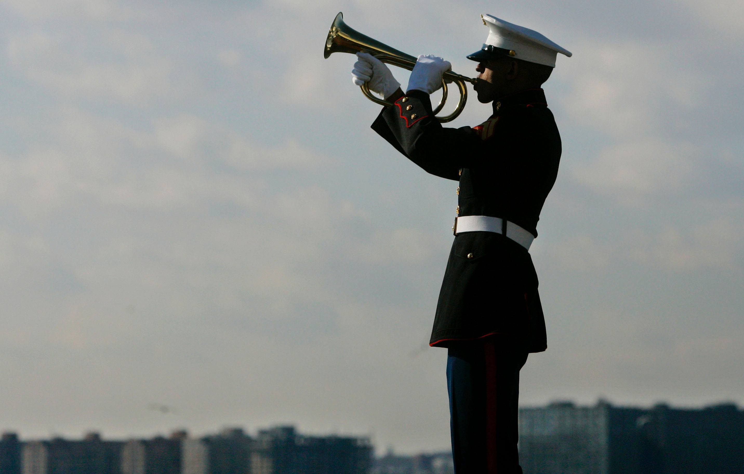 A U.S. Marine Corps bugler plays taps