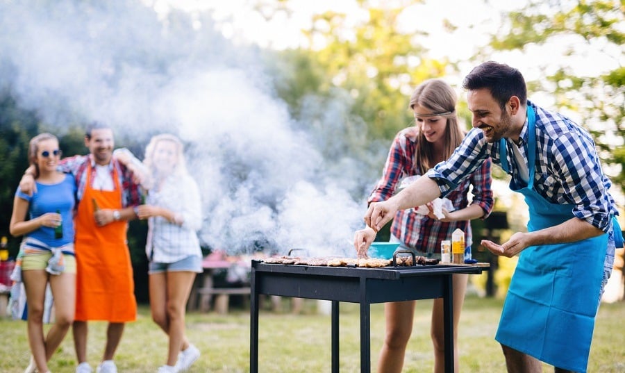 People in aprons cooking on grill People in aprons cooking on grill