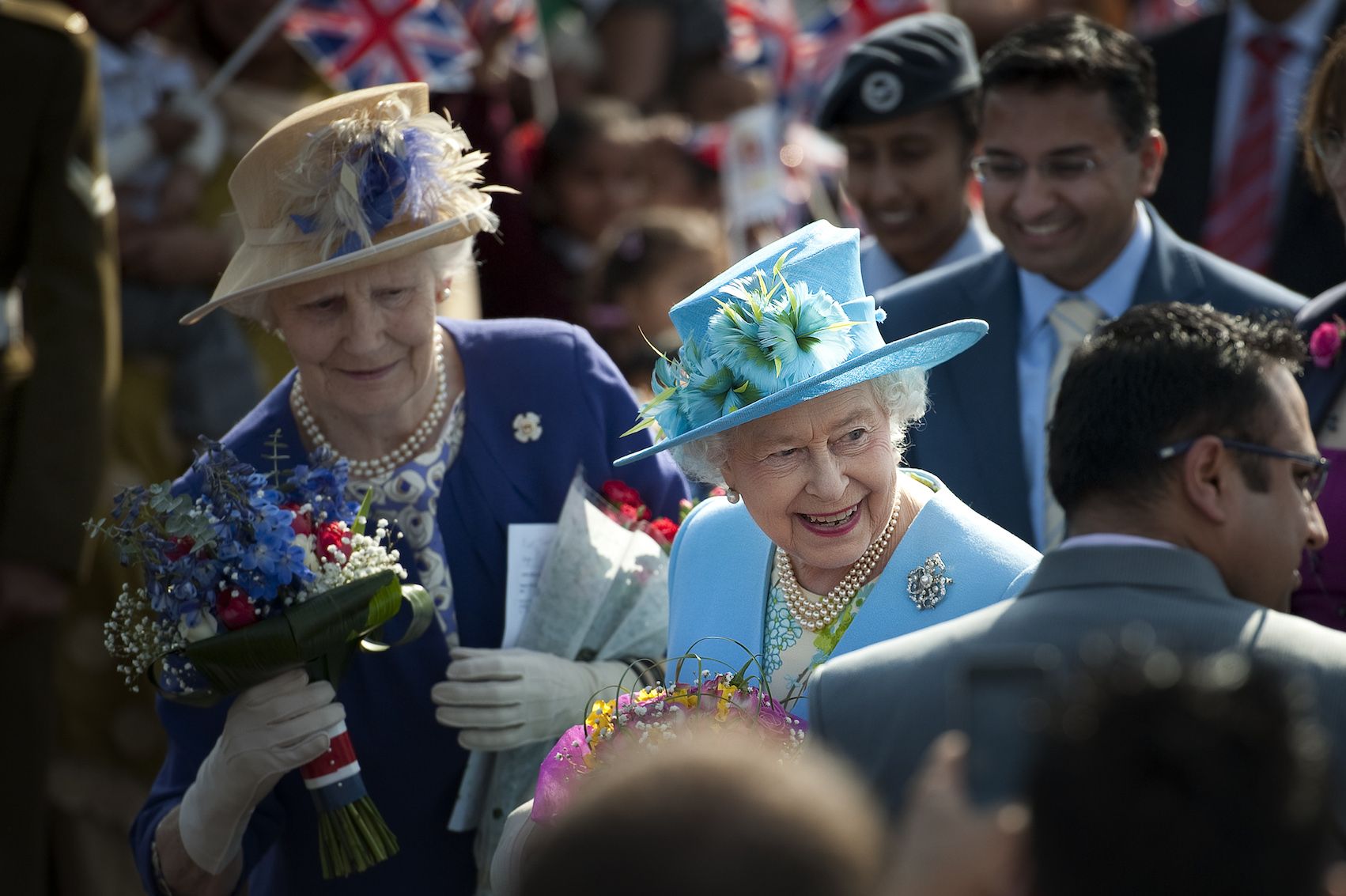 Britain's Queen Elizabeth II receives flowers from well-wishers followed by a lady-in-waiting