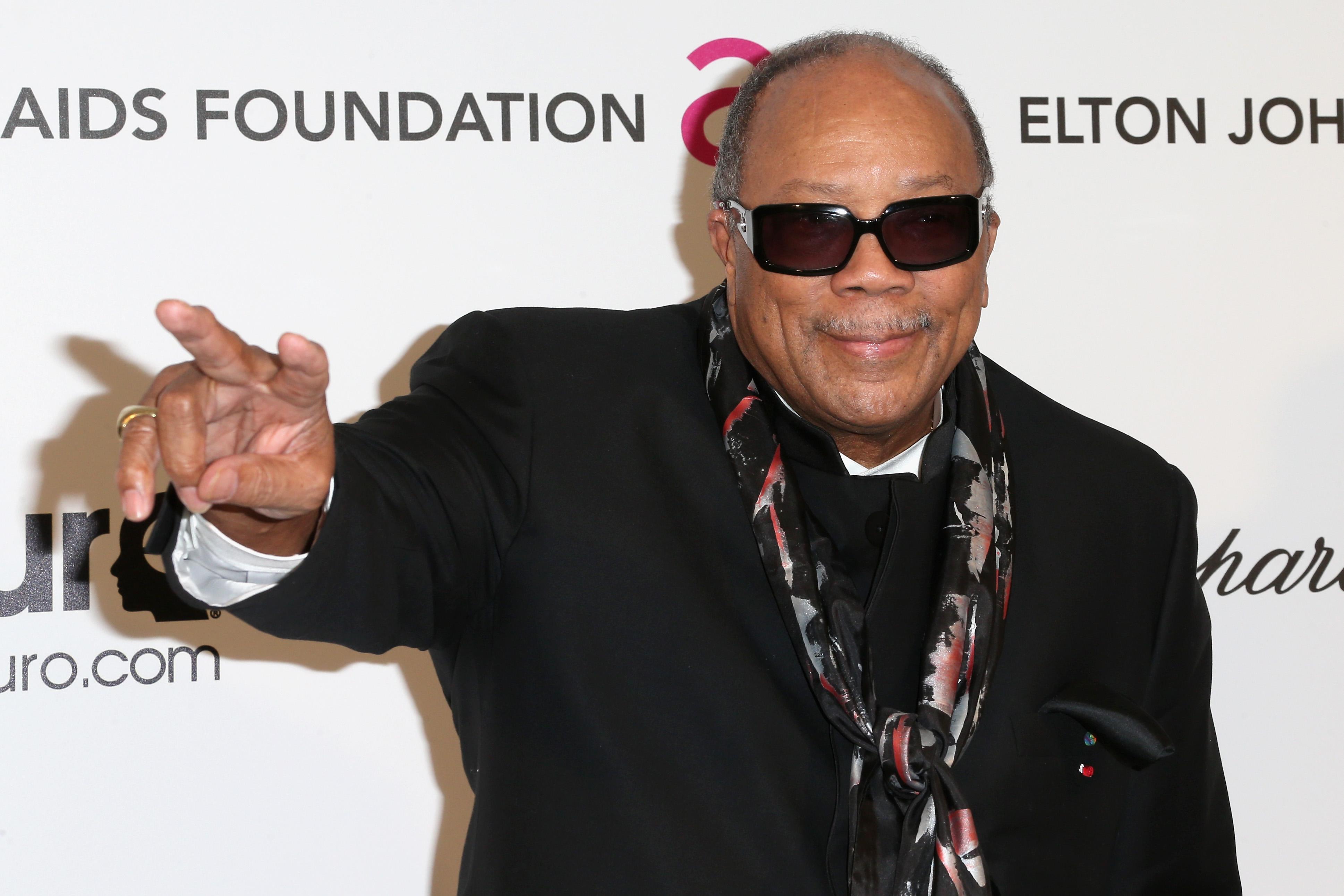 Quincy Jones gesturing and posing on a red carpet. Quincy Jones gesturing and posing on a red carpet.