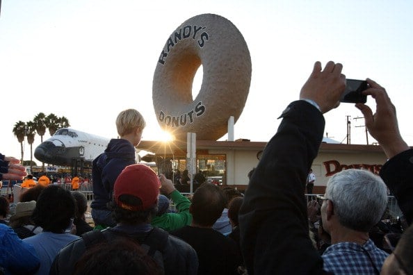 A crowd gathers outside of Randy's Donuts to watch the space shuttle Endeavour